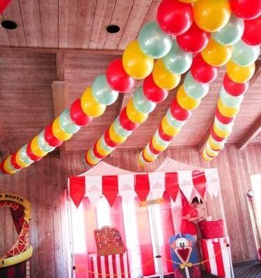 Färgglada heliumballonger i girlanger hänger i taket på en fest.